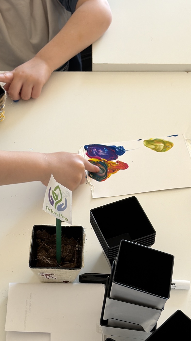 Colori e un vasetto con il logo Orto di Pino